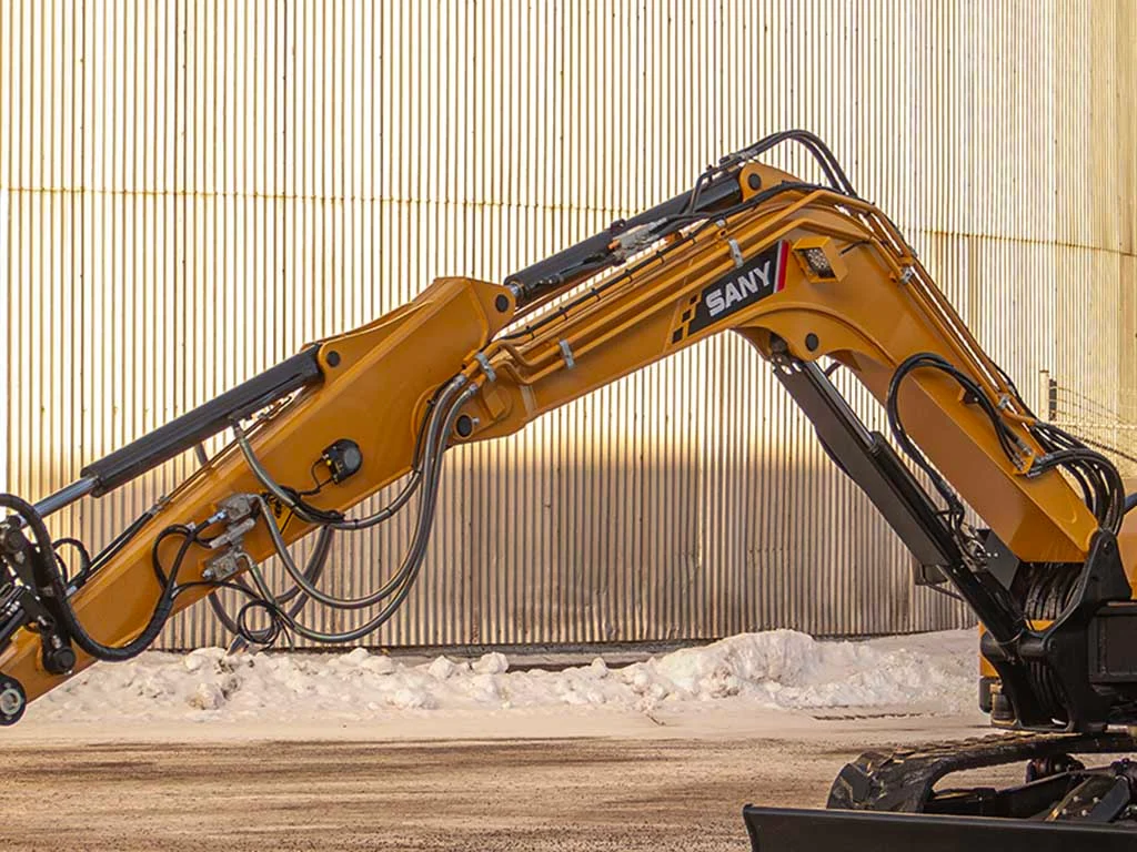 SANY kompaktgrävmaskin med lång bom och standardutrustning, redo för arbete på industriområde.