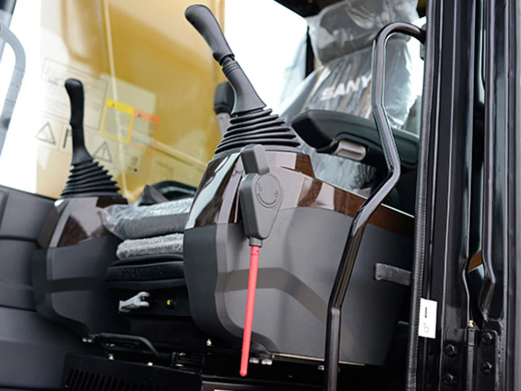 Interiör av SANYs C12-hytt med ergonomiska reglage och luftfjädrat säte för stora bandgrävare.
